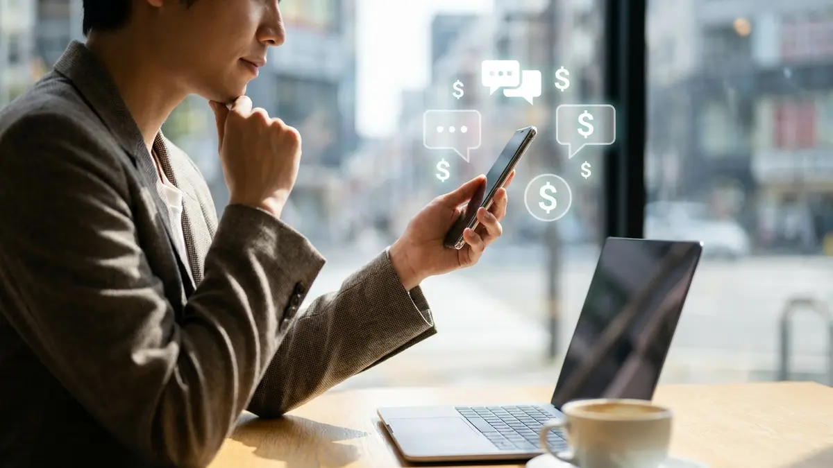 Pessoa olhando para o celular, com ícones de mensagens e dinheiro, simbolizando o custo do WhatsApp para empresas.